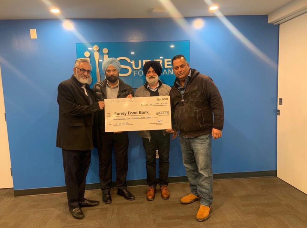 Perminder Chohan presenting a donation to the Surrey Food Bank