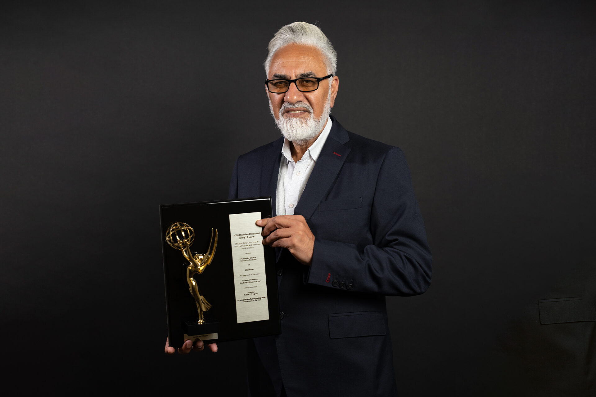 Perminder Chohan holding his Emmy Award
